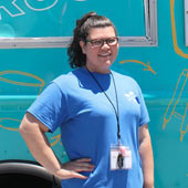 an image of Inspiring Summer worker in her blue shirt observing children at play